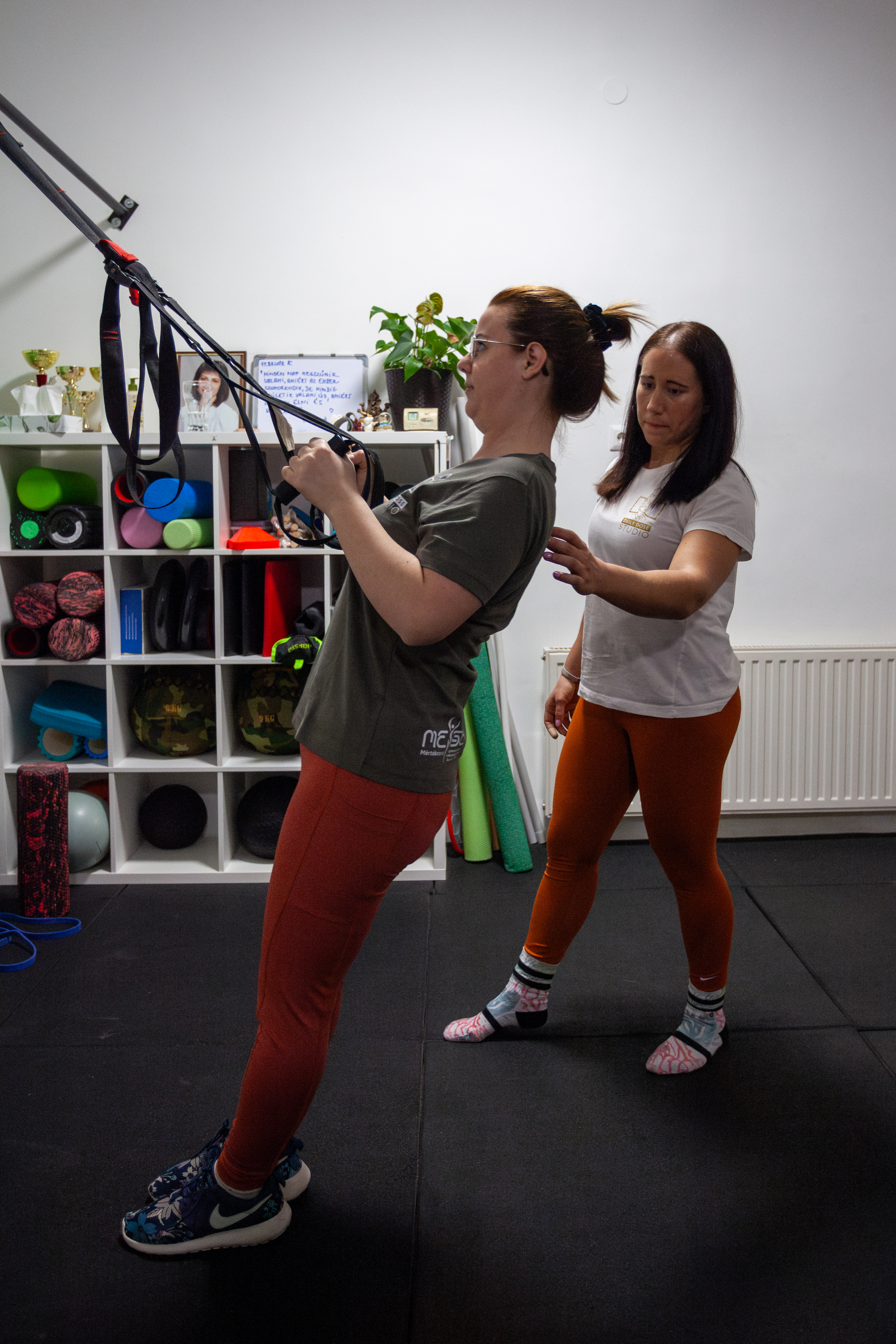 Kovács Kitti személyi edző segít egy kliensnek a helyes súlyzós gyakorlat végrehajtásában.